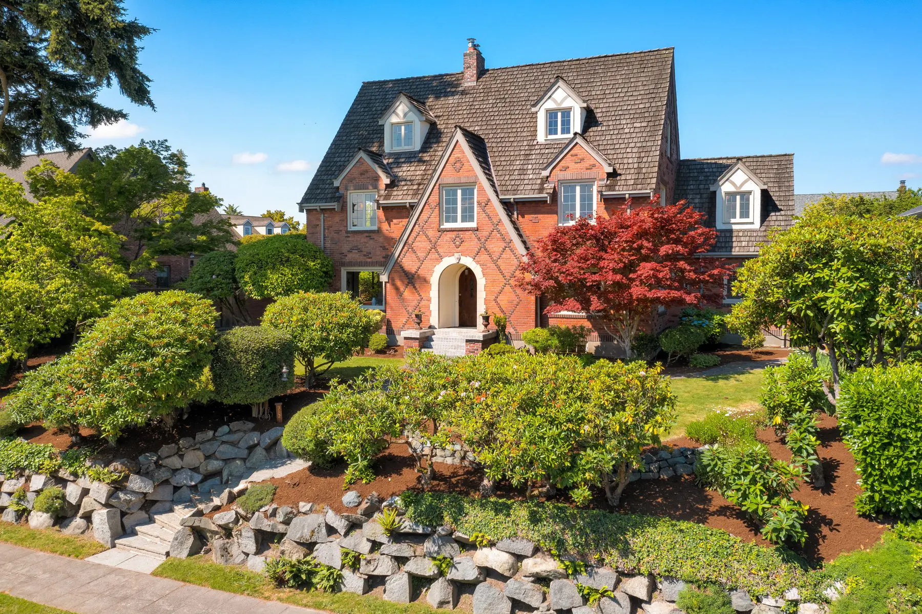 Brick Tudor-style house with landscaped front yard