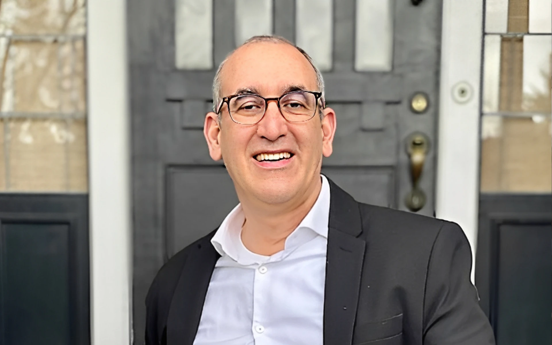 Man smiling in front of a door
