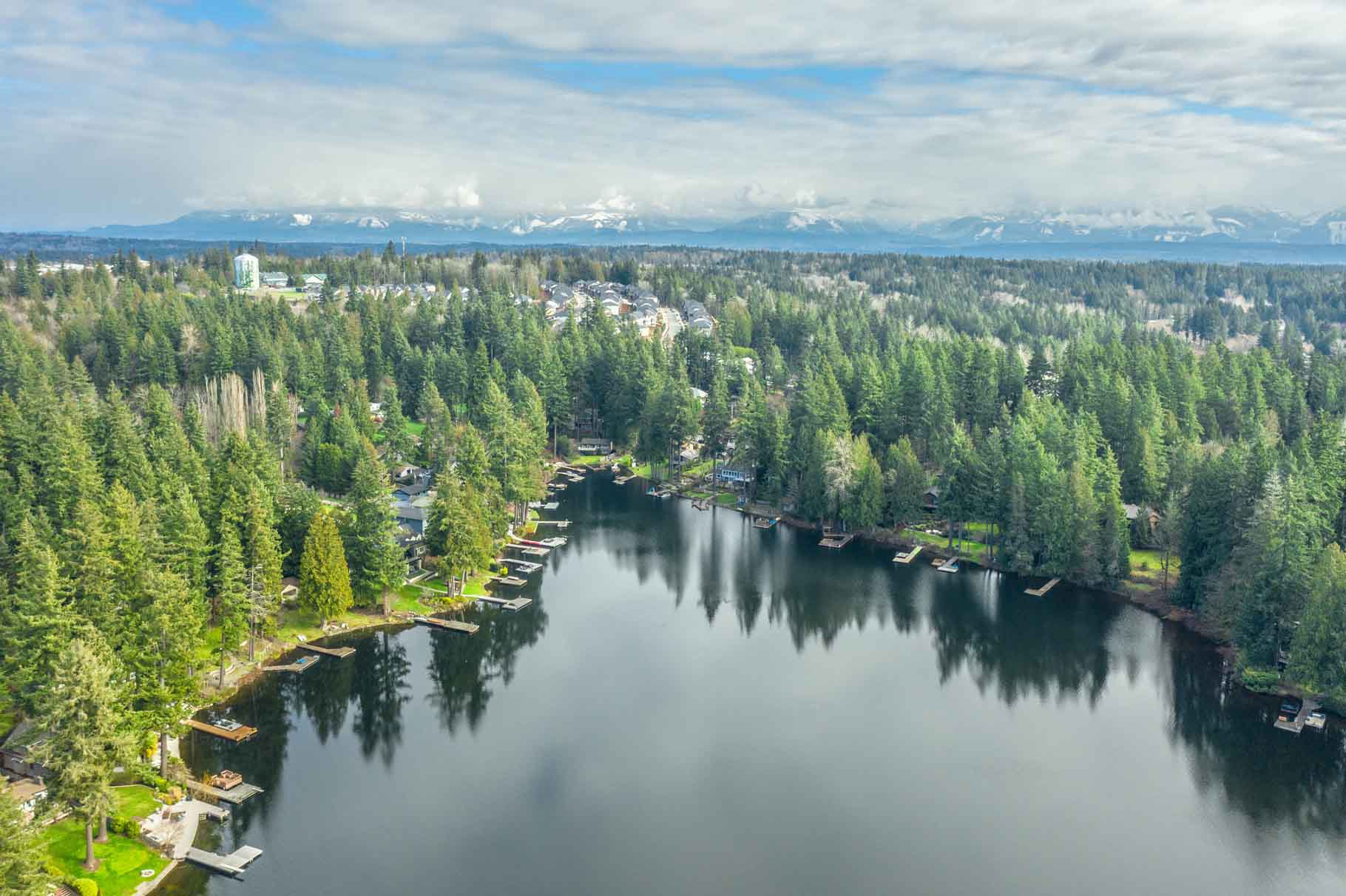 Aerial view of forested lake with docks